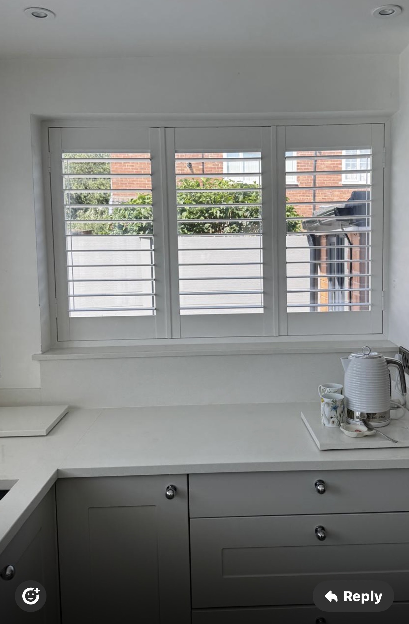 Kitchen window fitted with white shutters